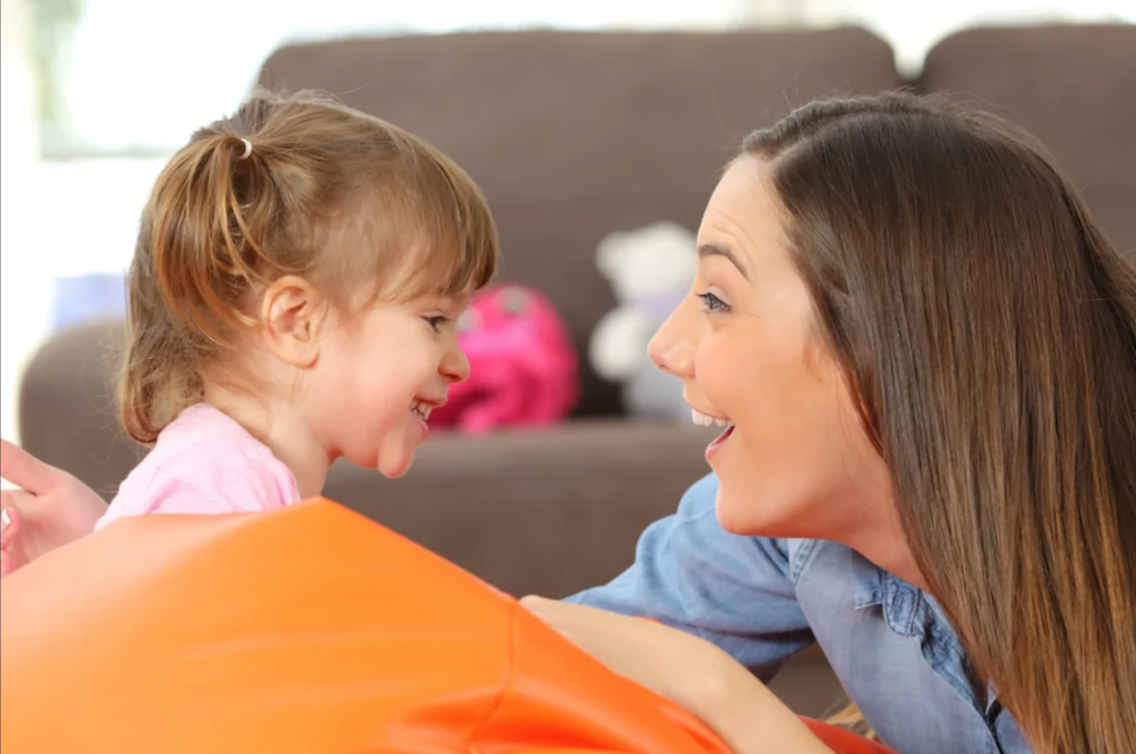 A young child learning to talk naturally with a parent, meaning-first